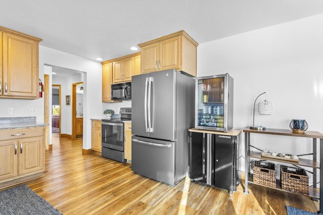 kitchen with stainless steel appliances, light countertops, light brown cabinetry, light wood-style floors, and recessed lighting