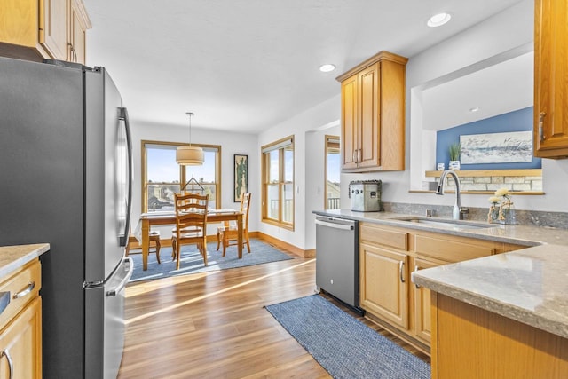 kitchen featuring recessed lighting, a sink, baseboards, appliances with stainless steel finishes, and light wood-type flooring