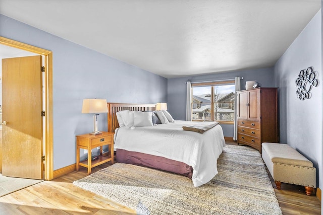 bedroom with baseboards and wood finished floors