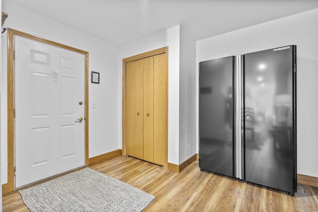 entryway with light wood-type flooring and baseboards