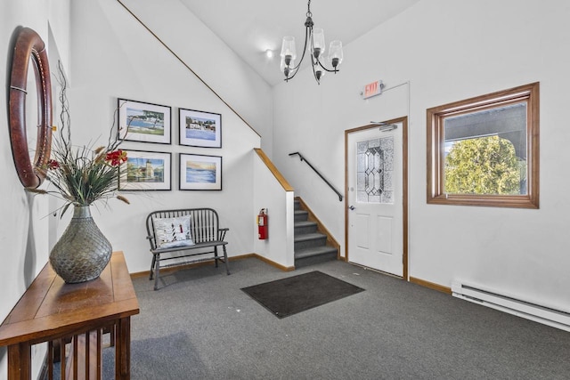 carpeted foyer featuring a baseboard heating unit, baseboards, stairway, and a notable chandelier