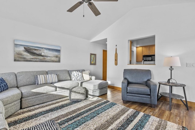 living area featuring high vaulted ceiling, ceiling fan, baseboards, and wood finished floors