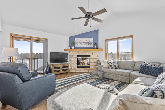 living room with lofted ceiling, a fireplace, a ceiling fan, and wood finished floors