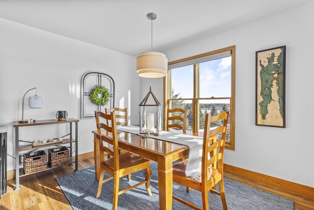 dining area with baseboards and wood finished floors