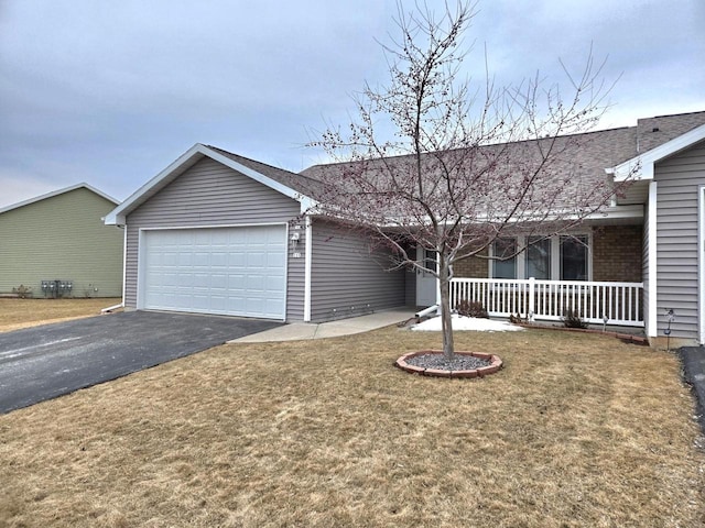 single story home featuring an attached garage, covered porch, aphalt driveway, and a front yard