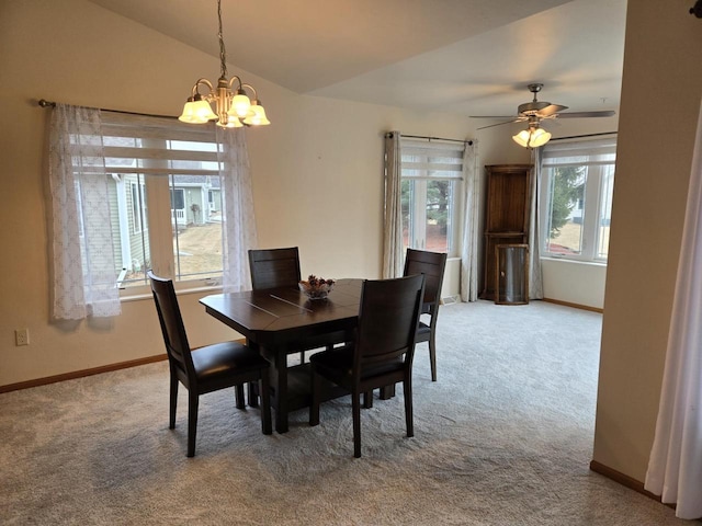 dining area featuring vaulted ceiling, carpet floors, ceiling fan with notable chandelier, and baseboards