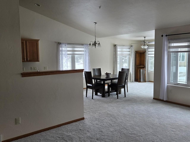 dining area featuring light carpet, plenty of natural light, a chandelier, and lofted ceiling