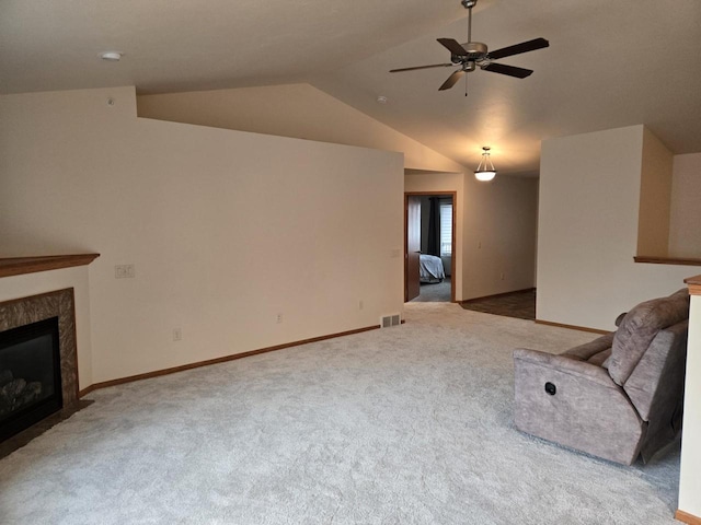 unfurnished living room featuring a premium fireplace, visible vents, a ceiling fan, vaulted ceiling, and carpet