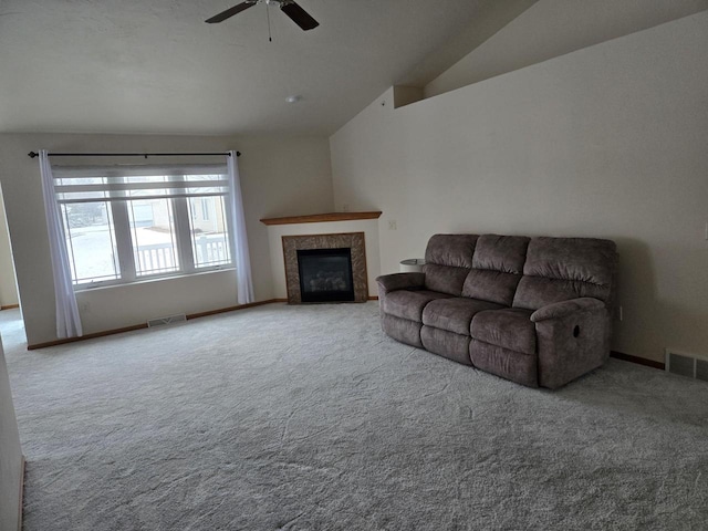 carpeted living room featuring visible vents, vaulted ceiling, a fireplace, and ceiling fan