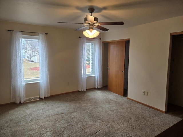 unfurnished bedroom with a ceiling fan, visible vents, baseboards, and carpet flooring