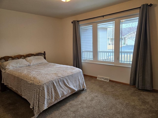 carpeted bedroom featuring baseboards and visible vents