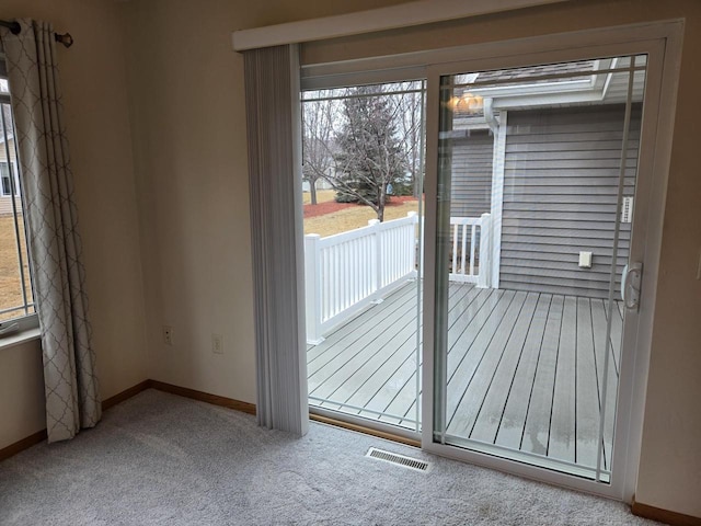 doorway to outside with carpet floors, baseboards, and visible vents