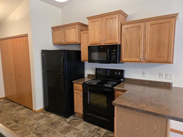 kitchen with dark countertops, baseboards, a peninsula, and black appliances