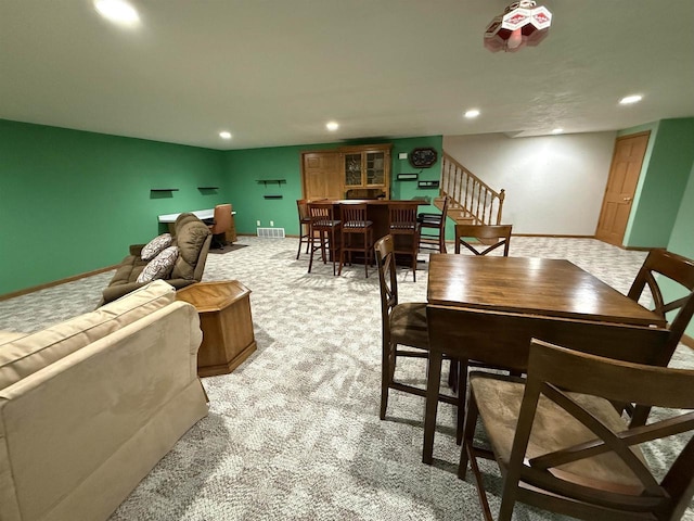 dining room with light carpet, visible vents, baseboards, stairway, and recessed lighting