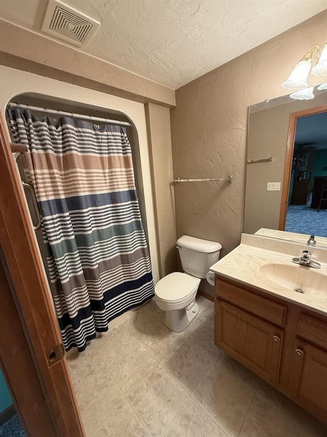 full bathroom featuring visible vents, a textured wall, toilet, a textured ceiling, and vanity