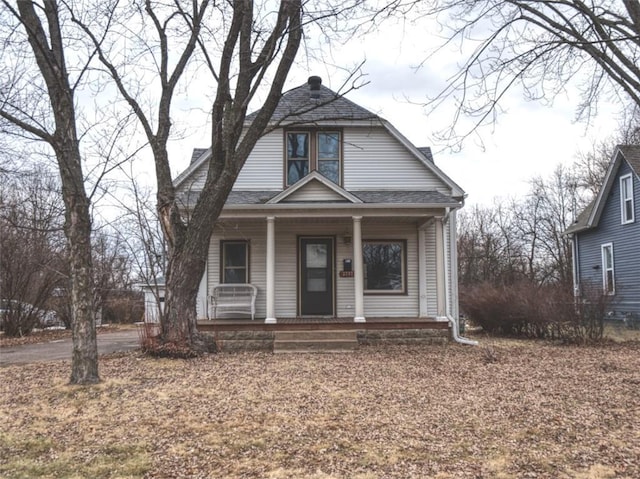 view of front of house featuring covered porch, roof with shingles, and a gambrel roof