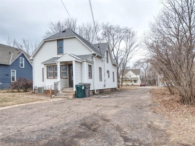 view of front of property featuring roof with shingles and central air condition unit