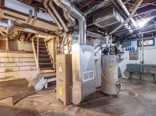 utility room featuring a sink, heating unit, and gas water heater