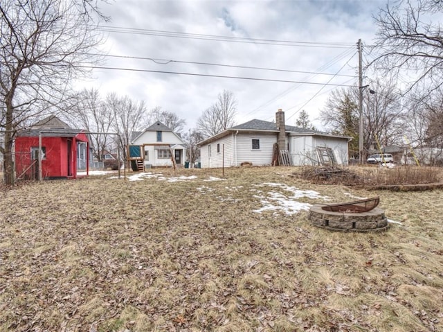 view of yard featuring an outbuilding, a fire pit, and a storage shed