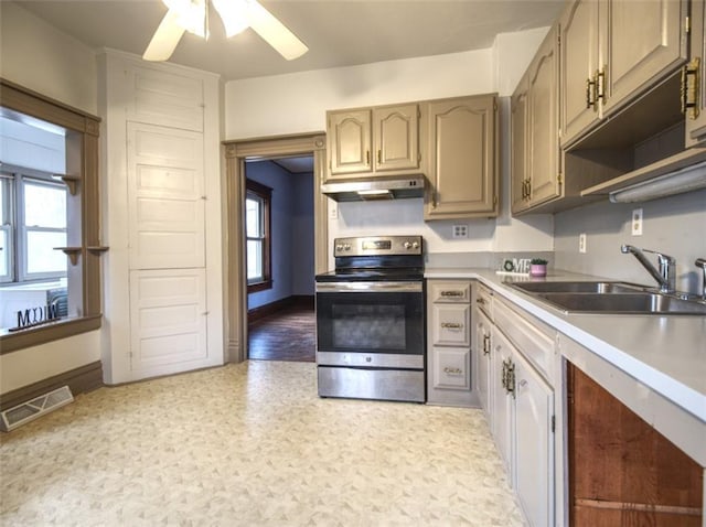 kitchen featuring under cabinet range hood, a sink, visible vents, light countertops, and stainless steel range with electric stovetop