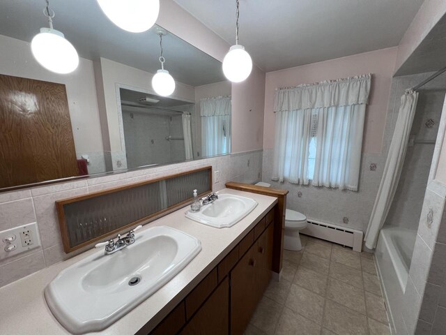 bathroom featuring a baseboard heating unit, toilet, a sink, and tile walls