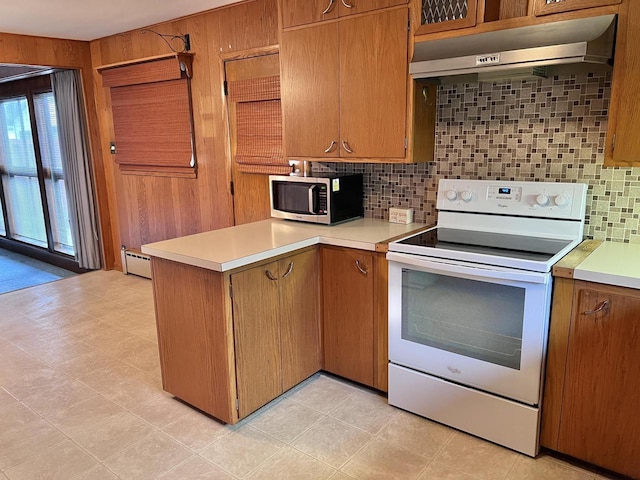 kitchen featuring under cabinet range hood, a peninsula, light countertops, white range with electric stovetop, and stainless steel microwave