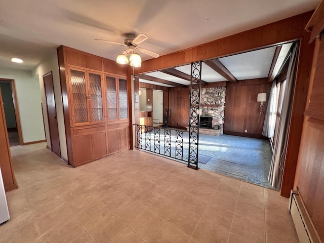 interior space featuring a baseboard radiator, beamed ceiling, and wooden walls