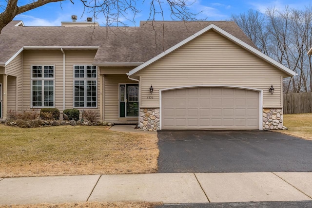 view of front facade featuring aphalt driveway, a garage, stone siding, roof with shingles, and a front yard