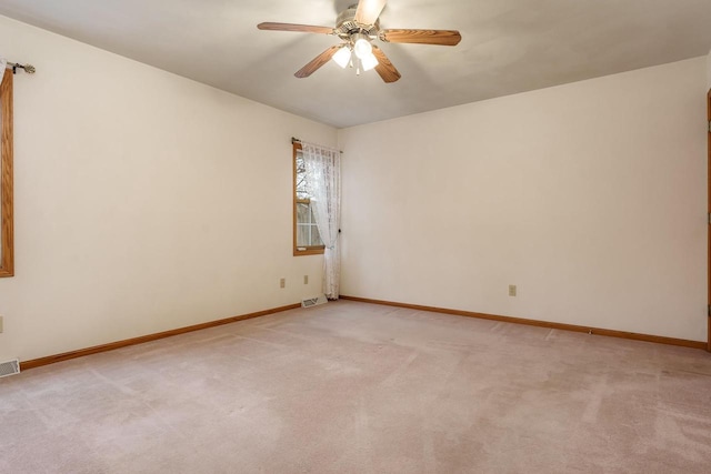 spare room with light carpet, baseboards, and visible vents