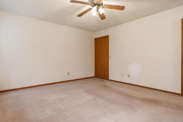 unfurnished room featuring a ceiling fan, light colored carpet, and baseboards