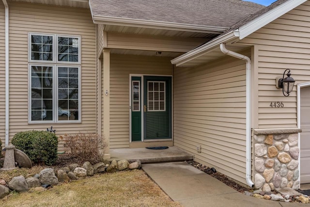 doorway to property with roof with shingles