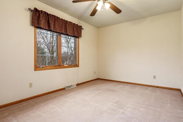 unfurnished room with baseboards, a ceiling fan, visible vents, and light colored carpet