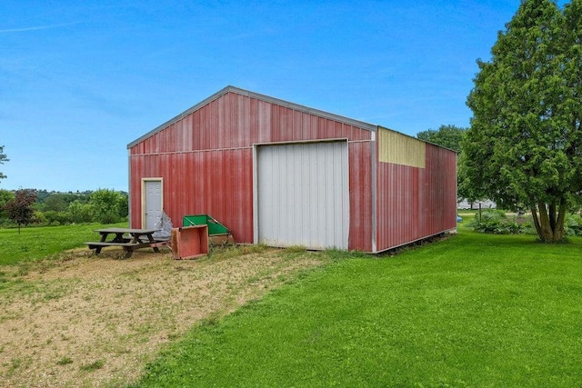 view of pole building with driveway and a lawn