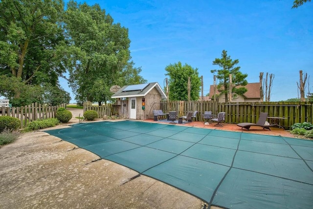 view of pool featuring a patio area, a fenced backyard, a fenced in pool, and an outdoor structure