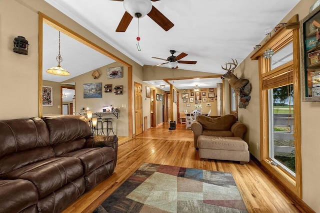 living area with ornamental molding, lofted ceiling, ceiling fan, and hardwood / wood-style floors