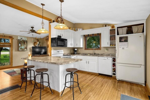 kitchen featuring white appliances, light wood-style flooring, vaulted ceiling, and white cabinets