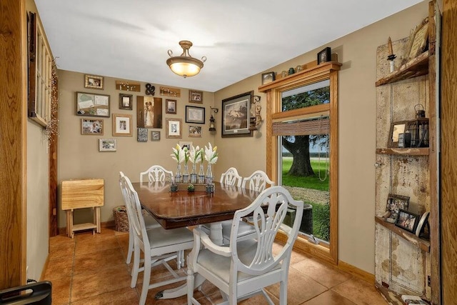 dining space featuring light tile patterned floors and baseboards