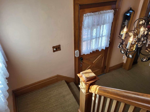 doorway to outside featuring carpet floors and baseboards