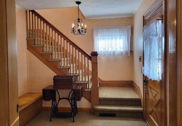 staircase with carpet floors, baseboards, and a notable chandelier