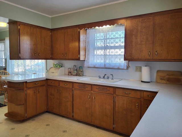 kitchen with light countertops, brown cabinetry, and a sink