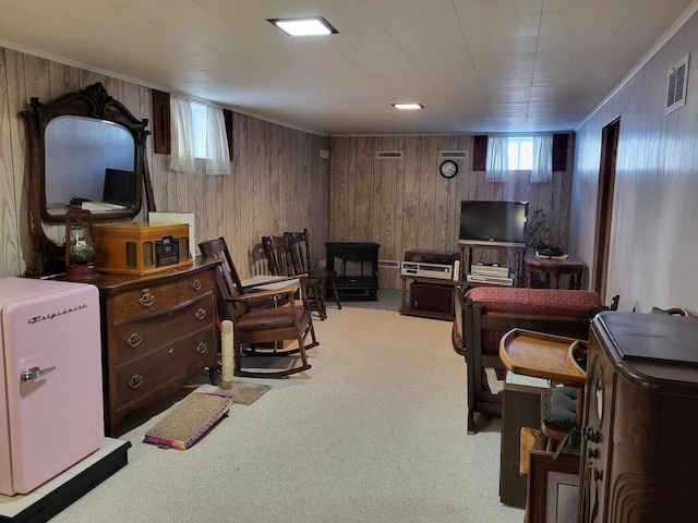 interior space with ornamental molding, wood walls, and visible vents