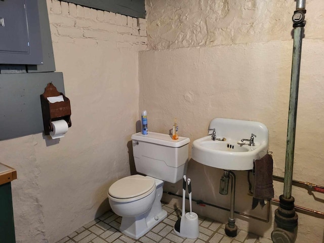 half bathroom featuring a sink, toilet, and electric panel