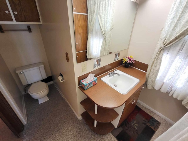 bathroom featuring vanity, toilet, and baseboards