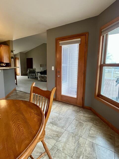 dining room featuring baseboards and vaulted ceiling