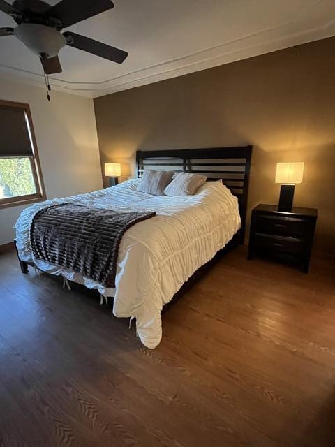 bedroom with ceiling fan, ornamental molding, and wood finished floors