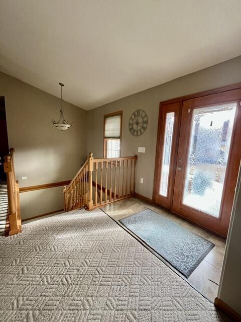 foyer with lofted ceiling and baseboards