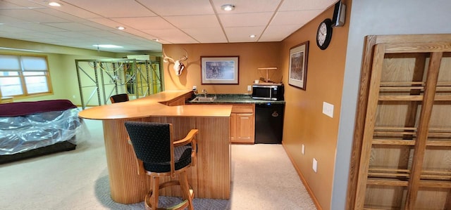 bar with black dishwasher, a paneled ceiling, light colored carpet, stainless steel microwave, and a sink