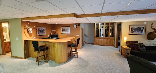 bar featuring light carpet, baseboards, indoor bar, stainless steel microwave, and a paneled ceiling