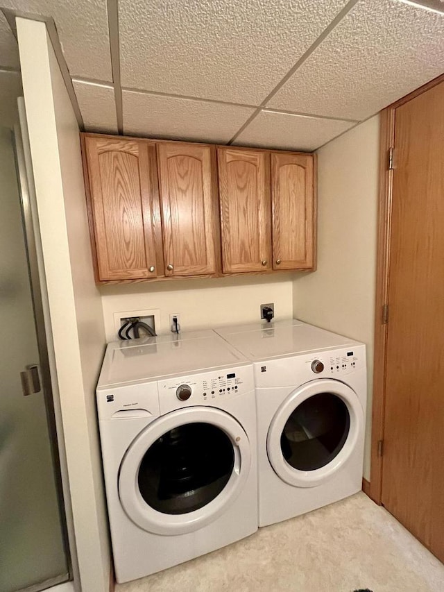 laundry area with washing machine and clothes dryer and cabinet space