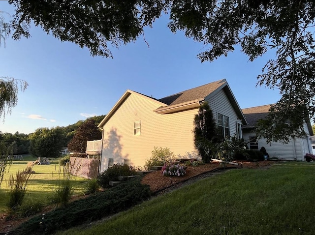 view of home's exterior featuring a lawn and fence